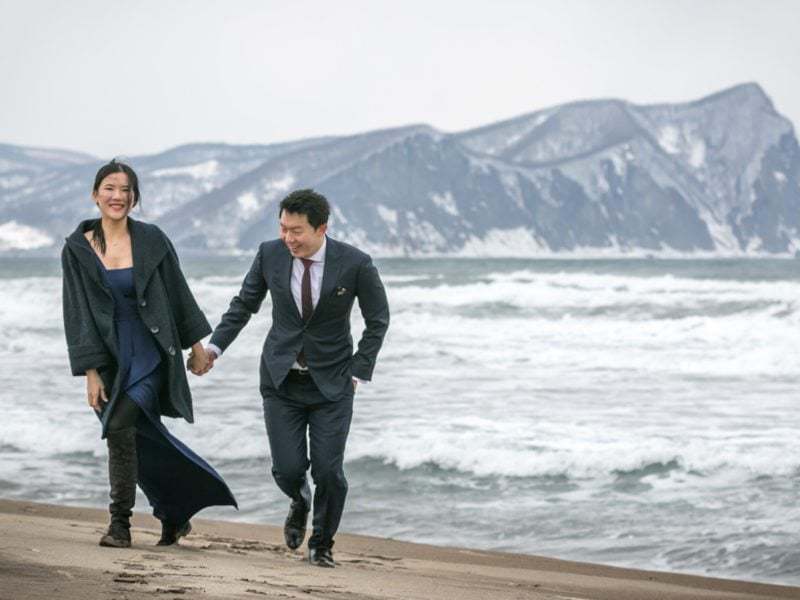 Walking on the beach for their engagement shoot in Otaru