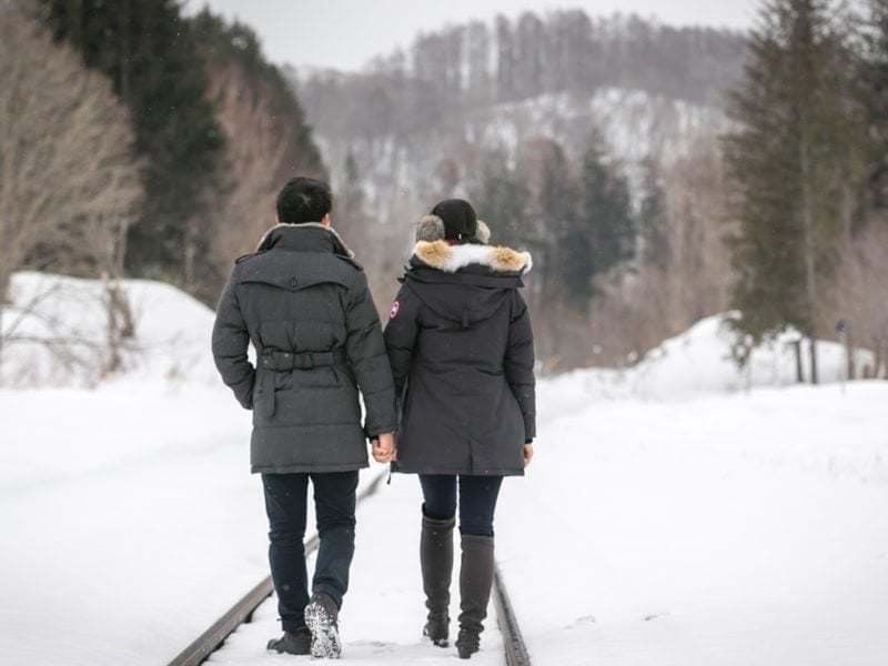 On the train tracks for their engagement shoot in Otaru