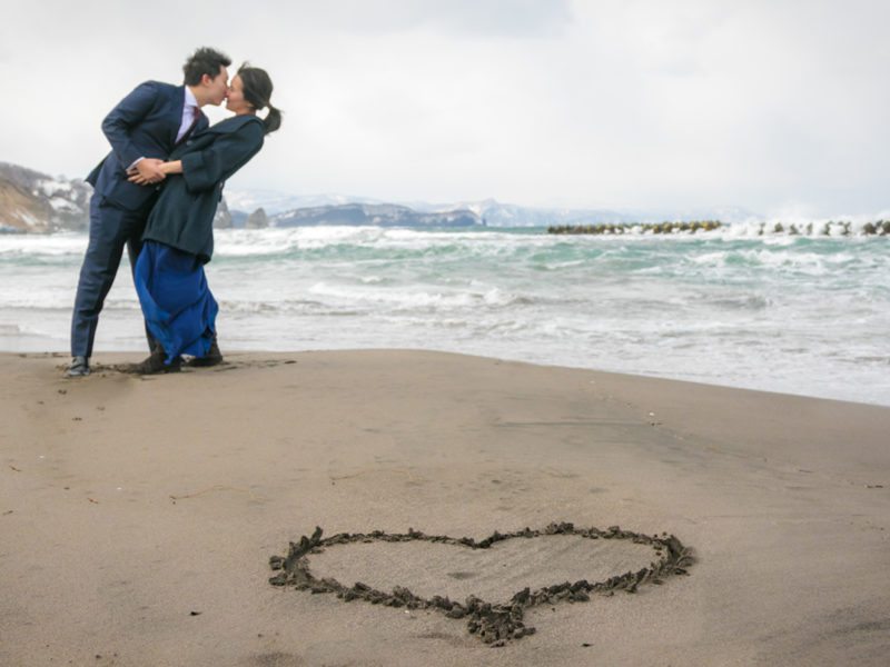 On the beach for their engagement shoot in Otaru