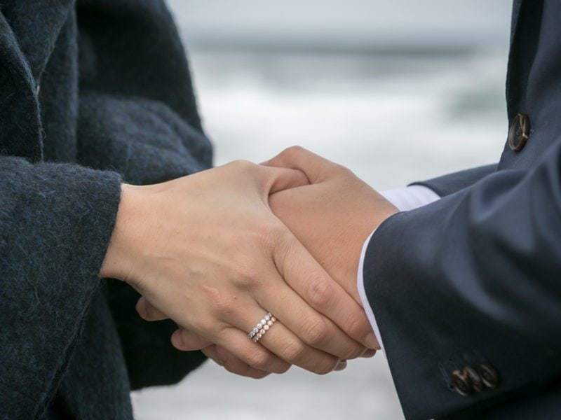 Holding hands on their engagement shoot in Otaru